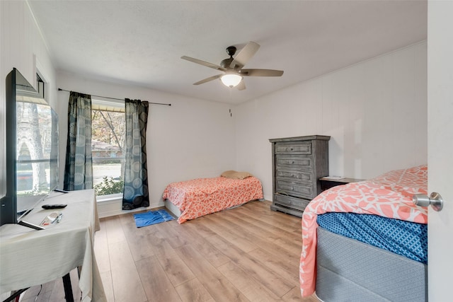 bedroom with light hardwood / wood-style flooring, ceiling fan, and crown molding