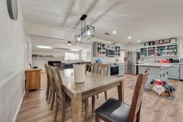 dining room with ceiling fan and light hardwood / wood-style flooring