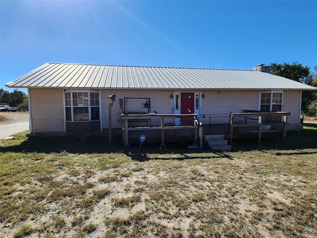 view of front of property with a wooden deck and a front lawn