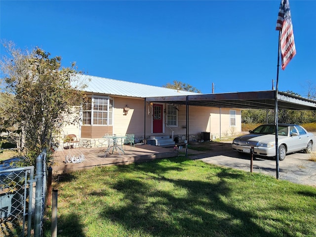 view of front facade featuring a carport, a deck, and a front lawn