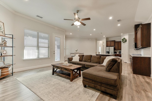 living room featuring light hardwood / wood-style flooring, ceiling fan, and ornamental molding