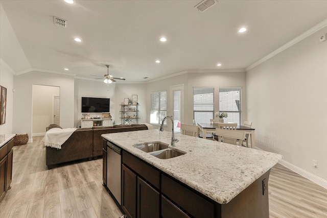 kitchen with a center island with sink, sink, light hardwood / wood-style flooring, ceiling fan, and ornamental molding