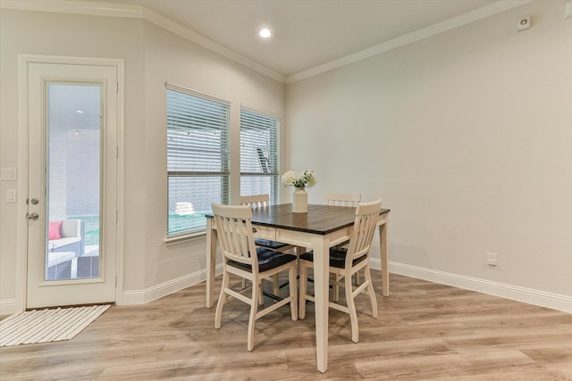 dining space with light wood-type flooring and crown molding