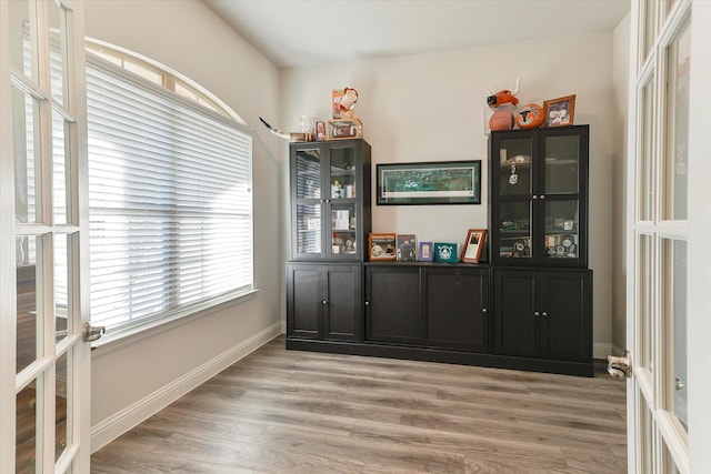 bar with hardwood / wood-style floors, a healthy amount of sunlight, and french doors