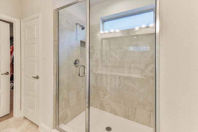 bathroom featuring a shower with door