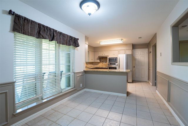 508 Squires Ln, Krugerville, TX 76227 - kitchen featuring decorative backsplash, appliances with stainless steel finishes, light tile patterned floors, white cabinets, and a peninsula