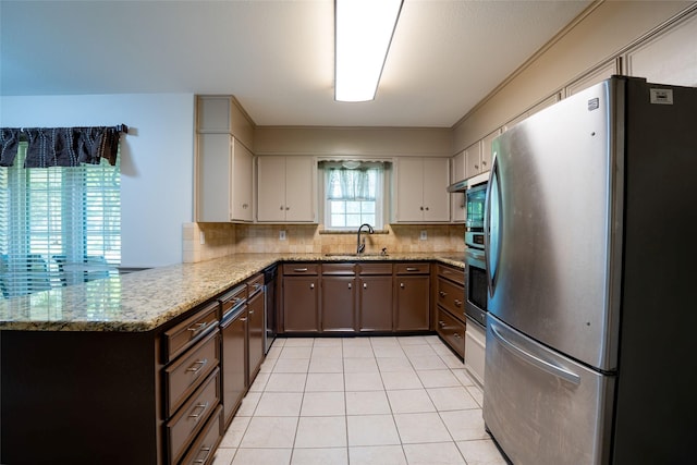 508 Squires Ln, Krugerville, TX 76227 - kitchen with light tile patterned flooring, appliances with stainless steel finishes, a sink, backsplash, and under cabinet range hood