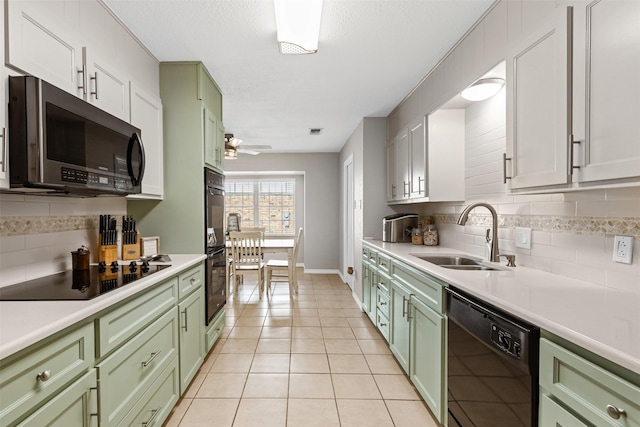 kitchen featuring light tile patterned flooring, sink, backsplash, and black appliances