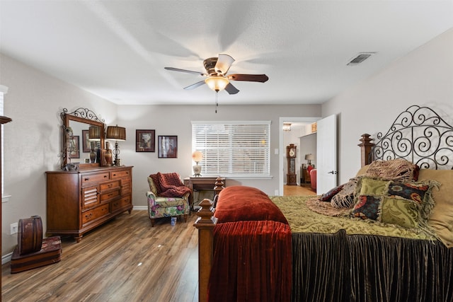 bedroom featuring hardwood / wood-style floors, a textured ceiling, and ceiling fan