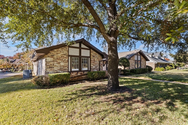 view of front of house with central AC and a front lawn