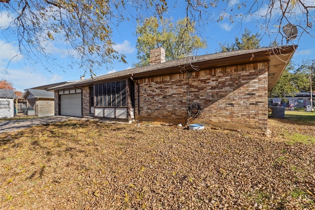 ranch-style house featuring cooling unit and a garage