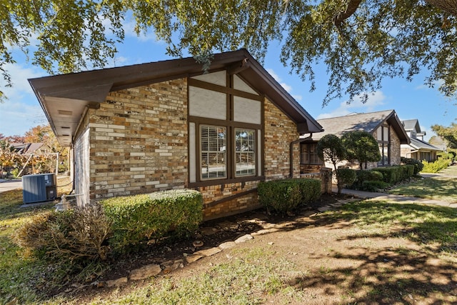 view of property exterior with a yard and central AC