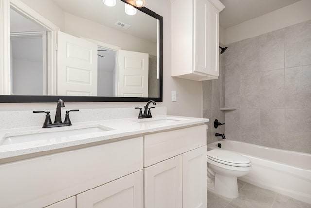 full bathroom featuring tile patterned flooring, vanity, tiled shower / bath combo, and toilet