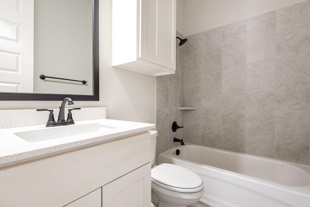 full bathroom featuring tiled shower / bath combo, toilet, and vanity