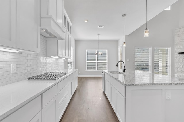 kitchen featuring white cabinetry, sink, light stone countertops, and appliances with stainless steel finishes