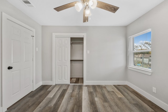 unfurnished bedroom with ceiling fan and dark wood-type flooring