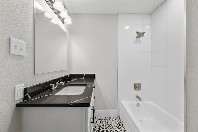 bathroom with tile patterned flooring, vanity, and tiled shower / bath combo