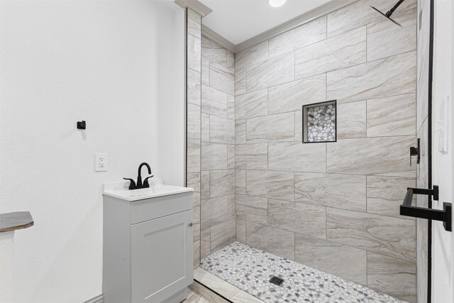 bathroom featuring tiled shower and sink