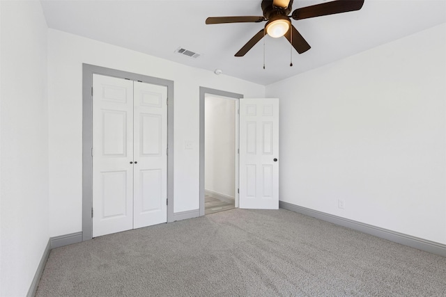 unfurnished bedroom with ceiling fan, a closet, and carpet floors