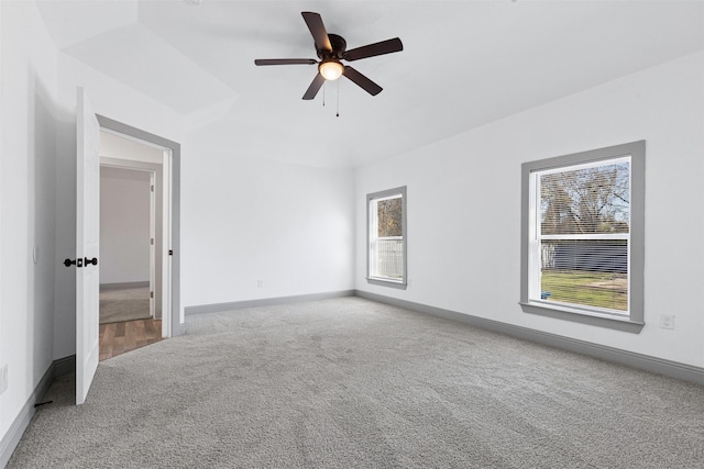 carpeted empty room with ceiling fan and a healthy amount of sunlight