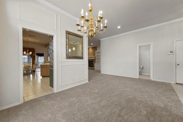 empty room featuring a fireplace, light colored carpet, crown molding, and an inviting chandelier