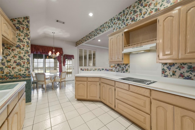 kitchen featuring white electric cooktop, hanging light fixtures, light brown cabinets, and a chandelier