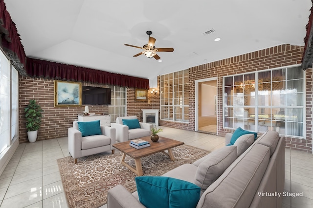 living room featuring tile patterned floors, a healthy amount of sunlight, and brick wall