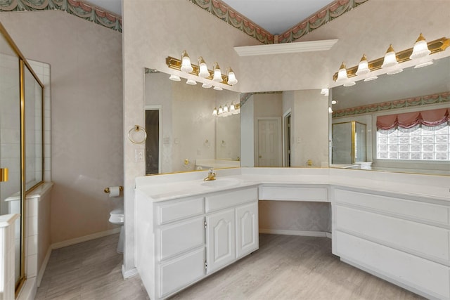 bathroom featuring toilet, vanity, a shower with shower door, and hardwood / wood-style flooring