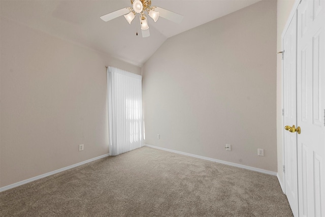 empty room with ceiling fan, carpet floors, and vaulted ceiling