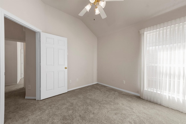 carpeted spare room featuring ceiling fan and vaulted ceiling