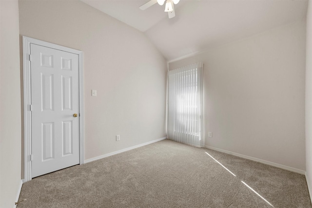 carpeted spare room with ceiling fan and vaulted ceiling