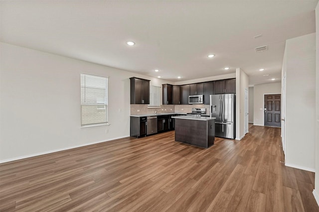 kitchen featuring dark brown cabinetry, a center island, light hardwood / wood-style floors, and appliances with stainless steel finishes