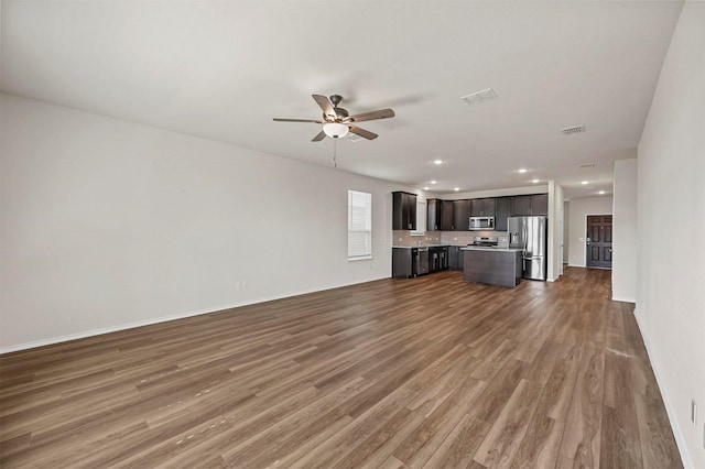 unfurnished living room featuring ceiling fan and dark wood-type flooring