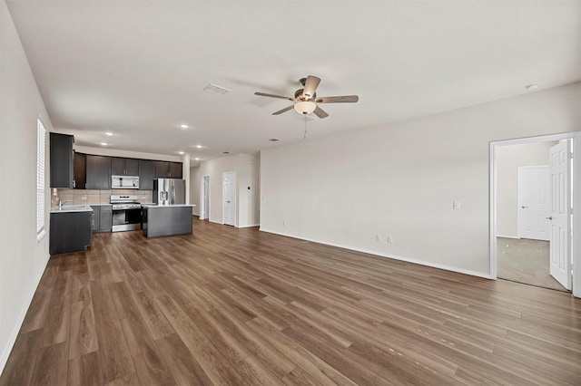 unfurnished living room with hardwood / wood-style flooring, ceiling fan, and sink