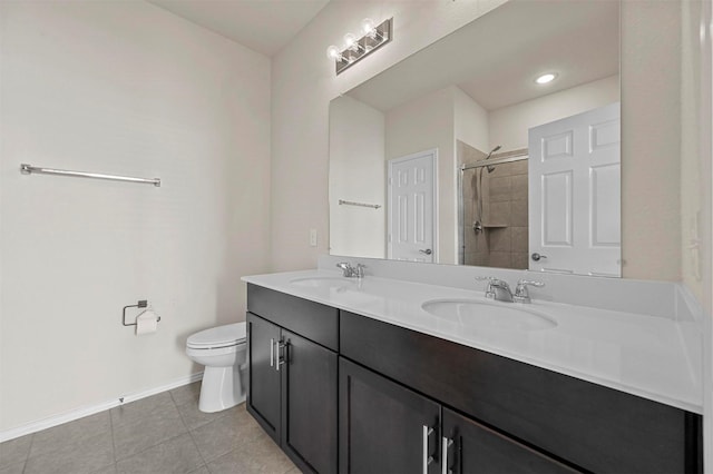 bathroom with tile patterned floors, vanity, tiled shower, and toilet