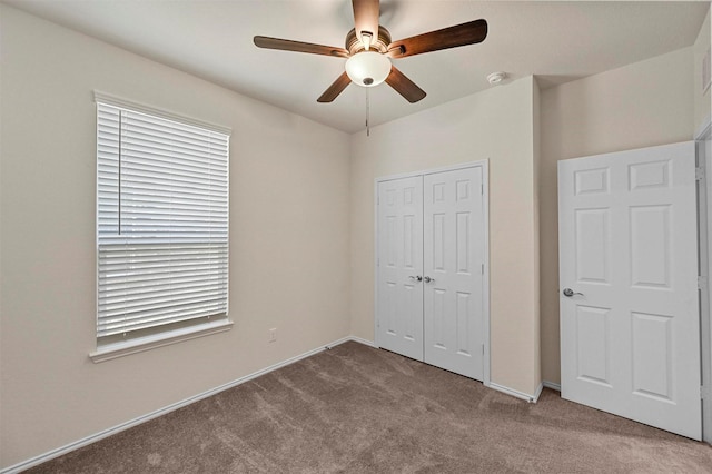 unfurnished bedroom with ceiling fan, a closet, and light colored carpet