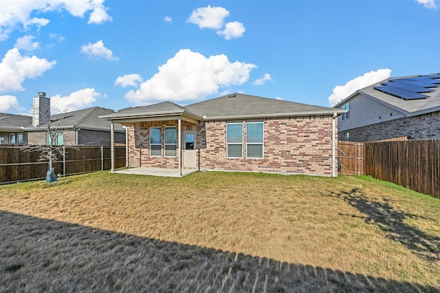 back of house with a lawn and a patio