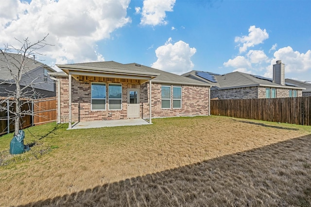 back of property featuring a yard and a patio