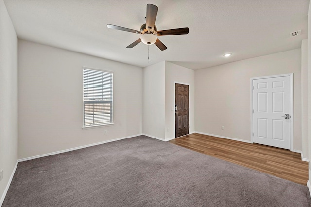 carpeted spare room featuring ceiling fan