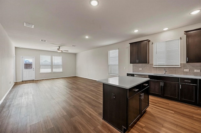 kitchen with a center island, sink, ceiling fan, tasteful backsplash, and light hardwood / wood-style floors