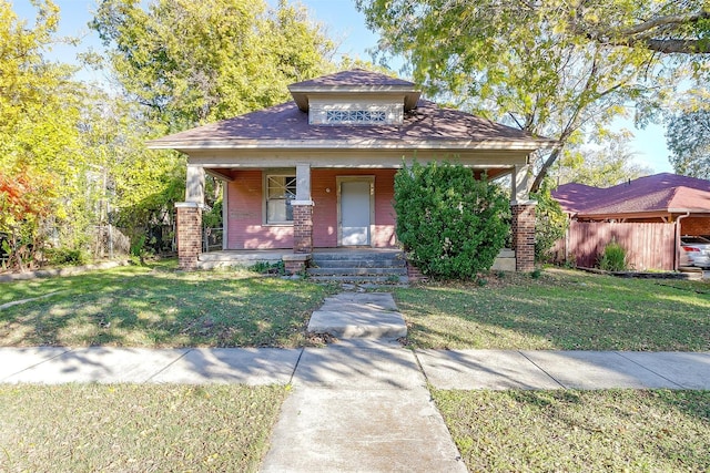 bungalow with a porch and a front lawn