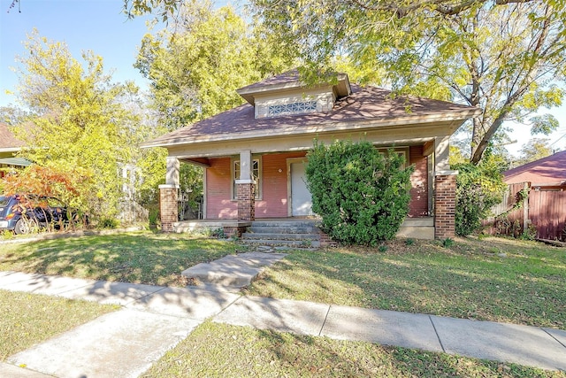 view of front facade featuring covered porch and a front yard