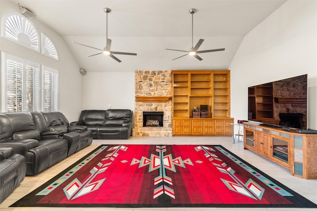 living room featuring a stone fireplace, ceiling fan, and built in shelves