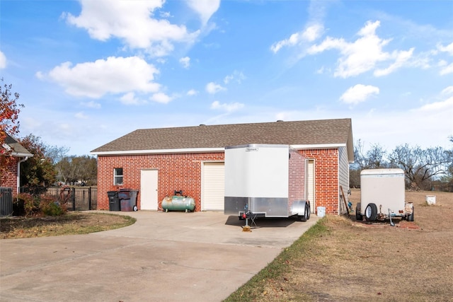 rear view of house with central AC, brick siding, a shingled roof, and fence