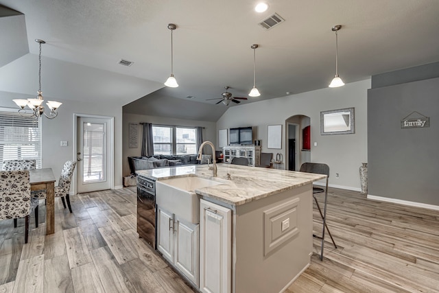 kitchen featuring sink, dishwasher, an island with sink, light hardwood / wood-style floors, and white cabinets