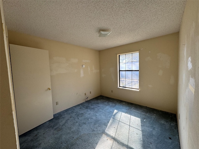 carpeted spare room with a textured ceiling