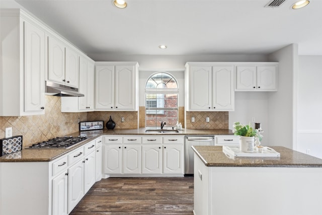 kitchen with white cabinets, sink, dark stone countertops, dark hardwood / wood-style flooring, and stainless steel appliances