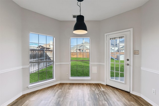 unfurnished dining area featuring hardwood / wood-style floors and a wealth of natural light