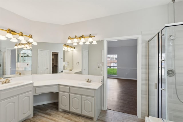 bathroom with walk in shower, vanity, and hardwood / wood-style flooring