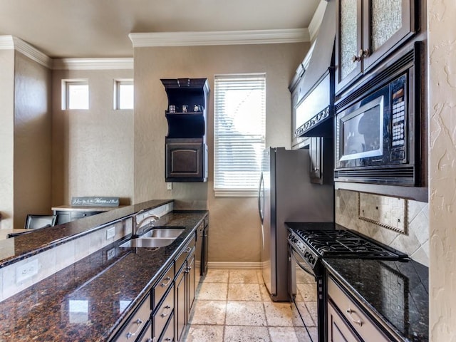 kitchen featuring a healthy amount of sunlight, stainless steel range with gas cooktop, sink, and black microwave